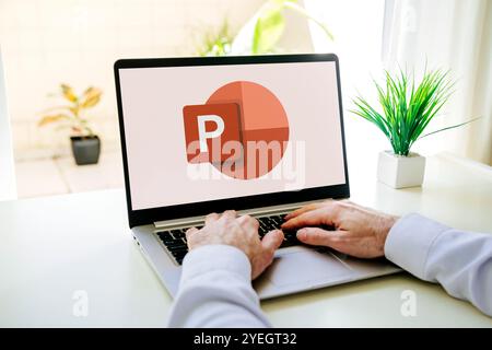 Man using a laptop computer displaying logo of Microsoft Office PowerPoint on the screen. Power point is a presentation program. ROSARIO, ARGENTINA Stock Photo