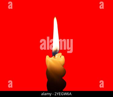 A single burning candle flame or light glowing on a small spiral white candle is isolated on red background with clipping path. Stock Photo