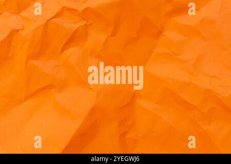 Top view and full frame of wrinkled or crumpled orange paper is used as crumpled orange paper background texture. Stock Photo