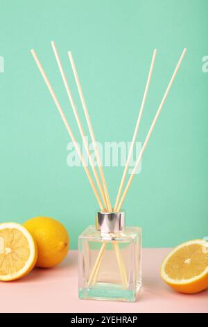 Reed diffuser and lemons on mint background. Top view Stock Photo