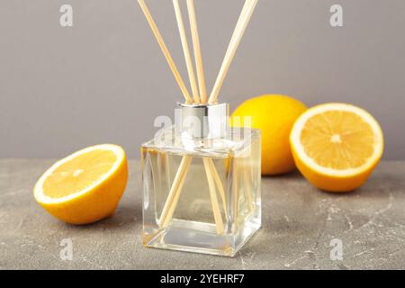 Reed diffuser and lemons on grey concrete background. Top view Stock Photo