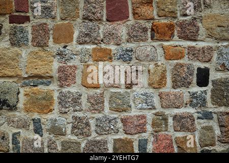 Old exterior building stone wall background. Naturally aged, colored bricks, no people Stock Photo