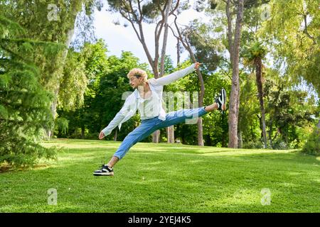 young man jumping and dancing contemporary ballet in the park with urban costume. Stock Photo