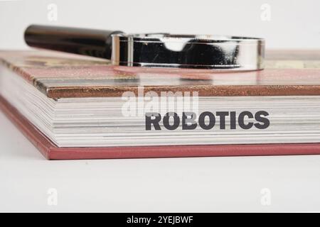 The concept of technology and development. Phrase, words, text ROBOTICS on the end of the book, a close-up front view. Stock Photo