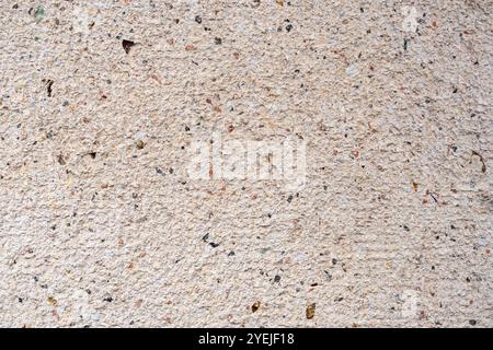 Close-up of a beige textured concrete wall, with specks of black and brown. Creative background for design and artwork. Stock Photo