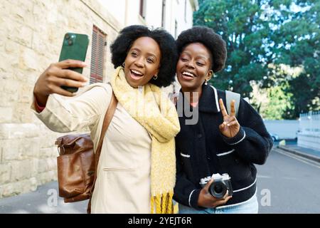 Joyful Friends Taking a Selfie Outdoors on a Sunny Day in the City Stock Photo