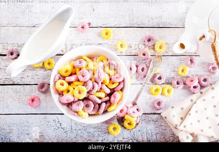 Falling colorful corn rings in bowl on white table Stock Photo