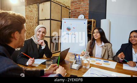Business meeting with diverse team, men and women focusing on strategies to grow the company, analytics discussion. Stock Photo
