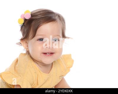 A close-up Beautiful Blue-eyed Baby Girl Smiling in Studio Shot, Wearing Yellow Dress, Close-up Portrait. Stock Photo