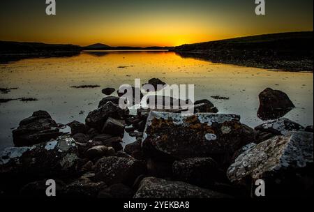 Sun setting over very calm sea Loch Stock Photo