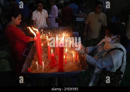 Kolkata, India. 31st Oct, 2024. A devotee lights a candle outside a ''pandal'' (a temporary platform), a decorated structure, on the occasion of the Kali Puja festival in Kolkata, India, on October 31, 2024. Kali is a Hindu goddess who represents the opposing forces of creation and destruction, death and rebirth, and time. (Photo by Rupak De Chowdhuri/NurPhoto)0 Credit: NurPhoto SRL/Alamy Live News Stock Photo