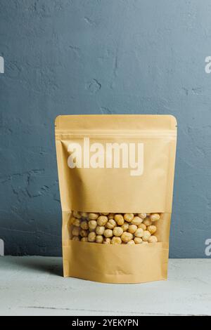 Roasted hazelnuts in a paper kraft bag. Delicious peanuts. Stock Photo