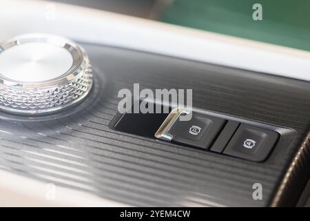Hand pressing the electric parking brake button in an electric vehicle. Image captures the concept of advanced automotive technology, emphasizing the Stock Photo