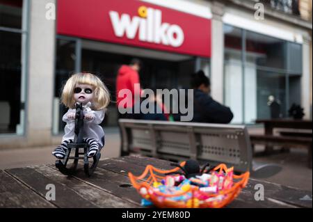 Cambridge, UK. 31st Oct, 2024. A Halloween puppet and free candy have been placed on tables on a pedestrian street in Cambridge.Halloween takes place every year on the 31st of October and people celebrate the day by dressing in spooky costumes, pumpkin carving, the giving of candy, and Halloween parties. Credit: SOPA Images Limited/Alamy Live News Stock Photo