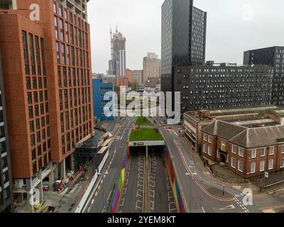 Urban landscape of birmingham city center with modern buildings, road, and colorful underpass entrance, offering an aerial perspective of transportati Stock Photo