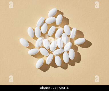 white pills on beige background, top view Stock Photo