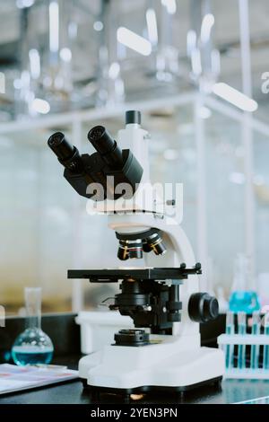Close-up of advanced microscope in a high-tech laboratory environment featuring equipment and glass containers in the background Stock Photo