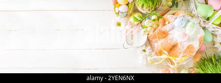 Easter sweets and decorations background, Sweet easter cake panettone with colorful painted eggs, spring grass and decor, copy space for text Stock Photo