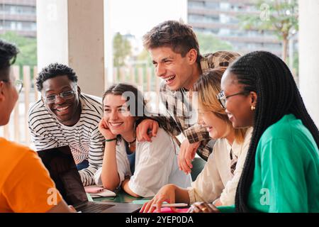 Diverse Group of College Students Collaborating on Project with a Laptop. High School Classmates Sharing Joyful Moment During Study Session: Modern Education and Inclusive Learning Environment. High quality photo Stock Photo