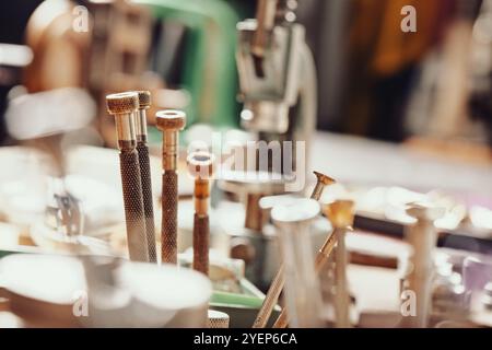 Vertical row of precision screwdrivers, each with knurled grips and color tips, organized on a workbench. The setup suggests readiness for fine tasks Stock Photo
