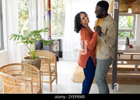 Dancing together at home, happy multiracial couple sharing joyful moment. happiness, togetherness, leisure, love, relationship, carefree Stock Photo