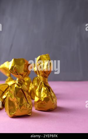 Cut chocolate truffle in a yellow wrapper on a gray background with space for copyspace text. Background: food, candy, chocolate. Handmade candies Stock Photo