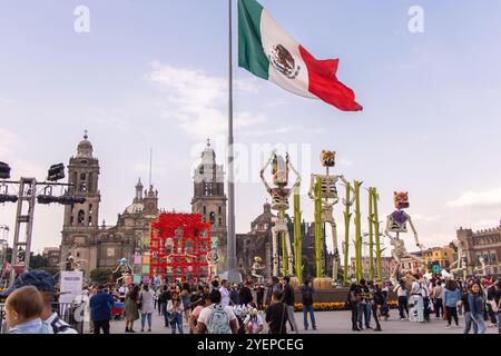 Large Mexican flag flies over Zócalo, surrounded by Day of the Dead