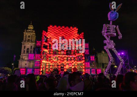 A vibrant Day of the Dead altar with illuminated decorations and skeletons lights up Zócalo at night, celebrating Mexican tradition. Dia de Muertos. Stock Photo