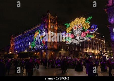 Brightly lit Day of the Dead decorations featuring skulls, flowers, and neon colors illuminate a Avenida 20 de Noviembre in downtown at night. Dia de Stock Photo