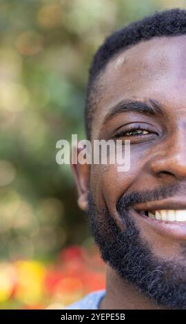 African american man standing outside, smiling in sunlight, radiating happiness and positivity. male, sunshine, cheerful, outdoors, joy, positive ener Stock Photo