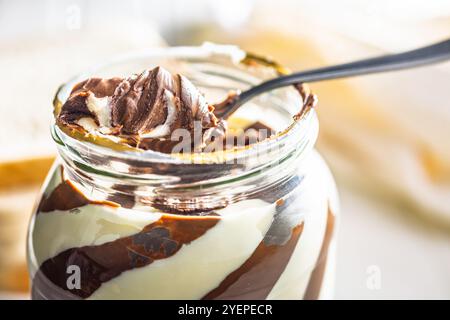 Chocolate cream spread on spoon in a jar. Stock Photo