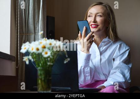 Businesswoman sending voice message via smartphone Stock Photo