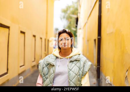 Woman in casual street style standing between yellow walls Stock Photo