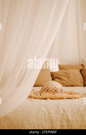 a straw hat is lying on the bed Stock Photo
