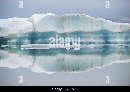 Ice formations are reflected in the still, misty water, Joekulsarlon glacier lagoon or Joekulsarlon, South Iceland, Iceland, Europe Stock Photo