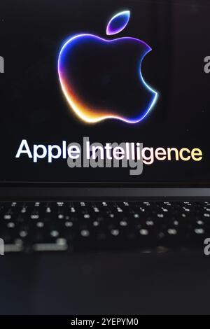 Apple logo in bright neon colours on a Macbook with illuminated keyboard and the text 'Apple Intelligence' underneath, symbolic image of artificial in Stock Photo