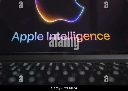 Apple logo in bright neon colours on a Macbook with illuminated keyboard and the text 'Apple Intelligence' underneath, symbolic image of artificial in Stock Photo