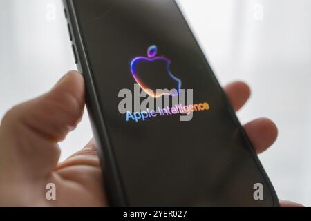 Hand holding iPhone with Apple logo and the text 'Apple Intelligence', bright and modern illustration, symbolic image of artificial intelligence Stock Photo