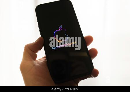 Hand holding iPhone with Apple logo and the text 'Apple Intelligence', bright and modern illustration, symbolic image of artificial intelligence Stock Photo