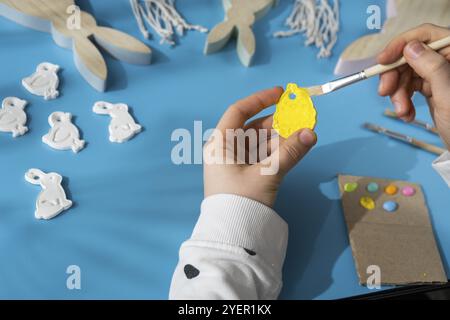 Master class of coloring Creator is using white air dry clay for making decor to EASTER holiday. Creating hobby recreation activity that involves fing Stock Photo