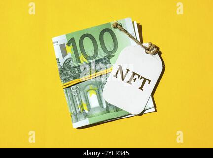 NFT non-fungible token text. Concept words NFT non-fungible token on paper blank. Background of euro bills. Blockchain asset crypto art, digital art, Stock Photo