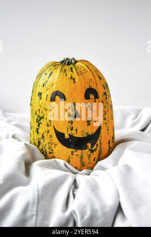 Pumpkin with painted face on a colored background for Halloween. Spider web. Holiday decorations. Card, copy space Stock Photo