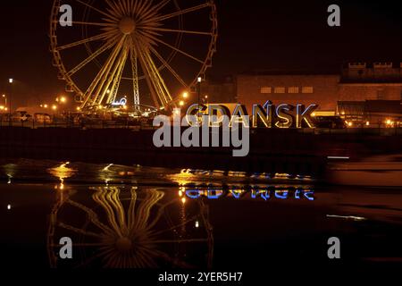 Gdansk Poland March 2022 Ferris wheel in the old town of Gdansk at night Reflection Blue and yellow colors of Ukrainian flag in Gdansk Poland Europe. Stock Photo