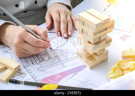 Architect designer Interior creative working hand playing a block wood game on desk architectural plan of the house, a color palette. Female architect Stock Photo