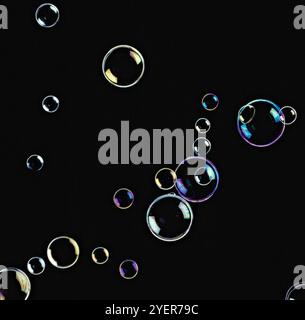 Soap bubbles floating in seven shining colours in black background ...