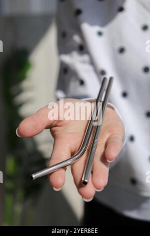Woman holding Reusable Metal Straw. Female Hand on reusable collapsible drinking straw. Eco lifestyle and zero waste concept. Plastic free. Stainless Stock Photo