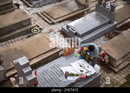 Madrid, Madrid, Spain. 1st Nov, 2024. A woman places flowers on a family member's grave at the Almudena cemetery during All Saints' Day celebrations.The Almudena cemetery is named after the patron saint of Madrid and is the largest cemetery in Western Europe. (Credit Image: © Luis Soto/ZUMA Press Wire) EDITORIAL USAGE ONLY! Not for Commercial USAGE! Stock Photo