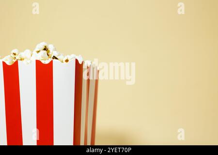 Close up of popcorn in a red cardboard carton bucket with white stripes on an isolated background, cinema food concept Stock Photo