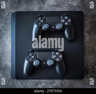 Khakiv, Ukraine - 02 May 2018: Top view of Sony Playstation 4 system with controllers on grey background. Home video game console Stock Photo