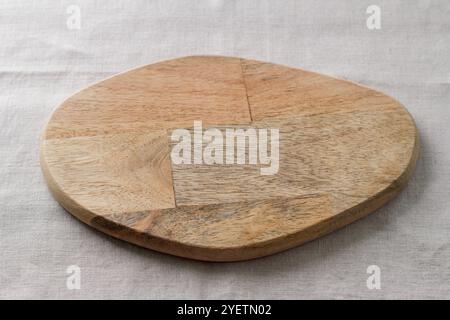 Empty wooden cutting board on a textile background, mockup for creative design Stock Photo
